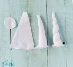 three pieces of white felt sitting on top of a wooden table next to each other