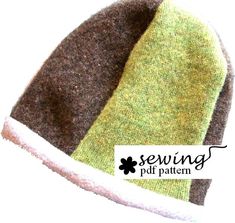 a green and brown hat with the word sewing on it's bottom corner, in front of a white background