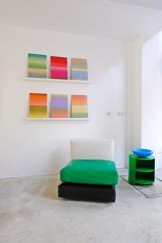 a green chair sitting in the middle of a living room next to a white wall