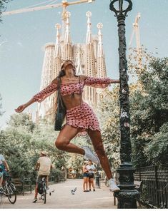 a woman is jumping in the air near a lamp post