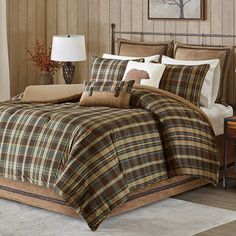 a bed with plaid comforter and pillows in a room