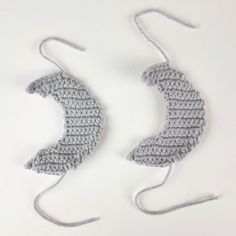 two crocheted ear hooks are shown on a white surface, one is gray and the other is grey