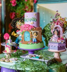 an elaborately decorated cake on a table in front of other cakes and decorations with flowers