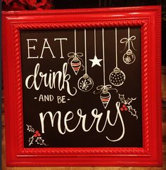 a red framed sign that says eat drink and be merry with ornaments hanging from it