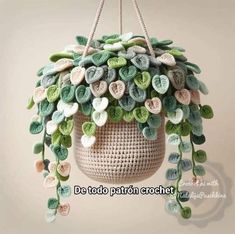 a crocheted planter hanging from the ceiling with green leaves on it's head