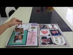 a person holding a pen and looking at pictures on a table with other items in it