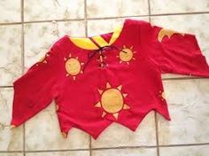 a child's red shirt with sun and moon designs on it sitting on the floor