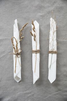 three white napkins tied with twine and dried plants