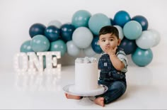 a little boy sitting in front of a cake