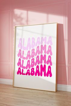 a pink and white poster with the words alabama on it in front of a pink wall