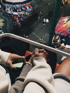 two people holding hands while looking down at an aerial view of a carnival park area