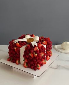 a cake made out of strawberries on top of a white plate with a bow