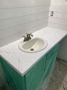 a white sink sitting on top of a green counter