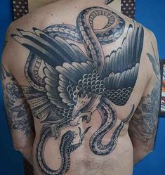 a man with tattoos on his back has a snake and bird tattoo on his chest