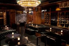 a dimly lit restaurant with black leather booths and chandelier hanging from the ceiling