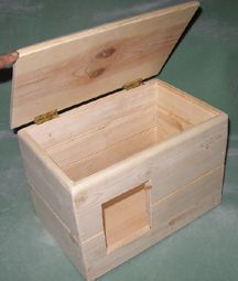 an open wooden box sitting on top of a green table next to a person's hand