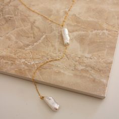 "This simple and dainty back drop necklace features two freshwater biwa pearls and looks great with backless tops and dresses. There is no clasp, it is completely reversible, so you can wear it in the front over a sweater or tee. So lightweight - you won't even know it's on! \"BIWA FRESHWATER PEARL BACK DROP NECKLACE\" by GoldenLinings - Christine Elizabeth Jewelry D E T A I L S Materials: 14K Gold Fill or Sterling Silver S I Z E S Measures 26\" (so you can put it over your head) Drop measures: Bridal Jewelry Simple, Jewelry Minimal, Simple Bride, Elizabeth Jewelry, Star And Moon Necklace, Biwa Pearls, Horseshoe Necklace, Crescent Necklace, Simple Pearl