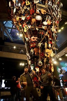 two men standing in front of a large display of guitars