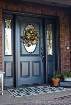 a black front door with a wreath on it