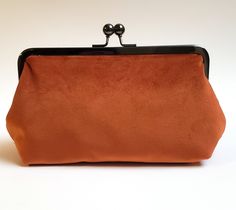 "Velvet rust orange clutch with 100% cotton rust orange lining. Handy pocket inside holds business cards, ID and credit cards. The purse is large enough to hold sunglasses, cell phones, pens, compacts...everything you need for a night out! Choose your metal purse frame finish: antique bronze (pictured), silver, rose gold or gunmetal Dimensions: 8\" wide metal frame on top, 8.75\" wide at the bottom, 3\" deep x 5\" tall Inside pocket measures 2\" x 4\". Add a personalized message of any length to Elegant Orange Rectangular Evening Bag, Elegant Orange Clutch As A Gift, Orange Rectangular Clutch For Formal Occasions, Orange Rectangular Formal Clutch, Elegant Orange Rectangular Clutch, Orange Pouch Clutch For Gift, Orange Pouch Clutch As Gift, Rectangular Orange Clutch For Gift, Rectangular Orange Clutch As Gift