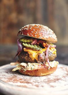 a cheeseburger with lettuce, tomato and other toppings on a plate