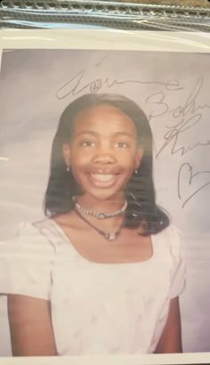 an autographed photograph of a woman in white shirt and necklace with her name on it