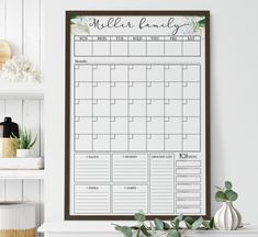 a wall calendar hanging on the wall next to a potted plant and other items