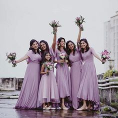 a group of women standing next to each other in front of a body of water