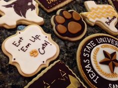 decorated cookies that say, let up the texas state seal and have paw prints on them