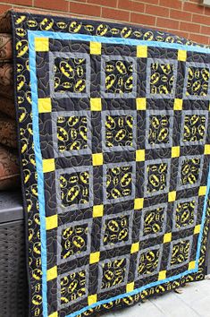 a black and yellow quilt sitting on top of a pile of wood next to a fire hydrant