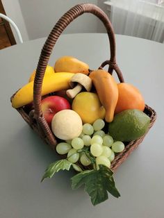 a wicker basket filled with assorted fruits and vegetables on top of a table