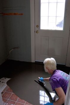 a young boy is using a vacuum to clean the floor in front of a door