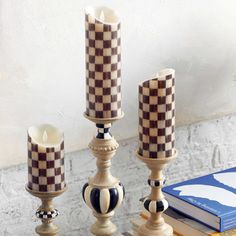 three candles sitting on top of a table next to a book