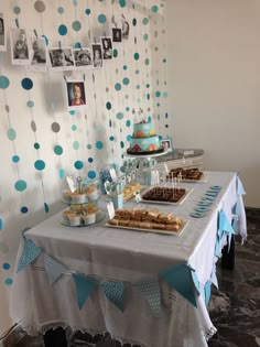 a table topped with lots of desserts next to a wall covered in blue and white polka dots