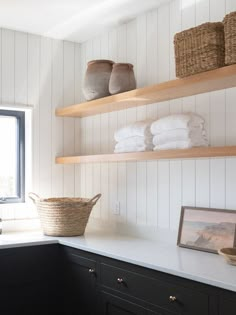 the shelves in this kitchen are filled with towels and other things to put on them