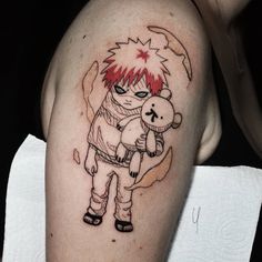 a person with a tattoo on their arm holding a teddy bear