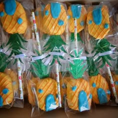 there are many pineapple shaped cookies in plastic bags with candles on them and palm trees