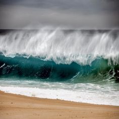 an ocean wave is breaking on the beach