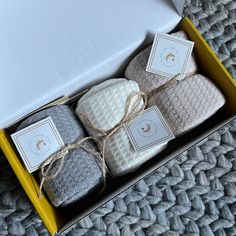 a box filled with different types of towels and soaps on top of a carpet