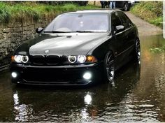 a black car driving down a flooded road