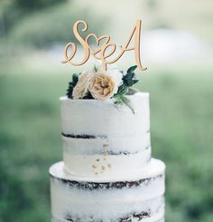 a wedding cake with white frosting and flowers on top that says se & a