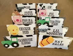 several farm animals and tractor themed tags on a wooden table with text that reads, pig, chicken, sheep, hay bales