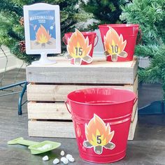 three red buckets sitting on top of a wooden table next to a christmas tree