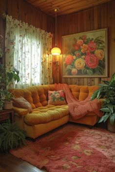 a living room filled with lots of furniture and flowers on the window sill next to a painting