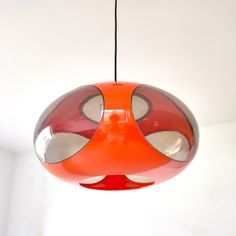 an orange and red lamp hanging from a ceiling