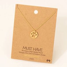 a gold necklace with a dog's paw print on the front and back of it