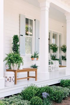 the front porch is decorated with potted plants