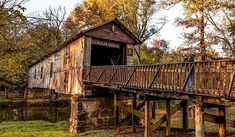 an old wooden covered bridge over a river