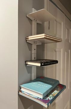 three books are stacked on the wall next to each other in front of a door