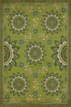 a green rug with an ornate design on the front and back side, in various colors